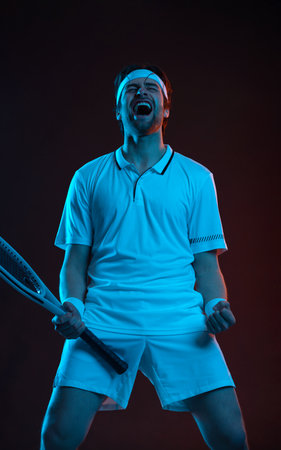 Tennis. Happy tennis player celebrating victory. Sport athlete with racket in white t-shirt.の写真素材