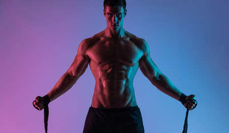 Boxing concept. Sportsman muay thai boxer fighting in gloves. Isolated on neon background. Copy Space.の写真素材