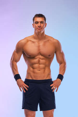 Man athlete isolated on color background. Gym full body workout. Muscular man athlete in fitness gym have havy workout. Sports trainer on trainging. Fitness motivation.の写真素材