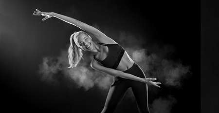 Strong athletic fit woman on black background wearing in the sportswear. Fitness and sport motivation.の写真素材