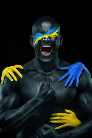 Flag of Ukraine painted on a face of soldier. War between Ukraine and Russiaの写真素材