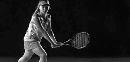 Tennis player. Beautiful girl teenager and athlete with racket in sporswear and hat on tennis court. Fashion and sport concept.の写真素材