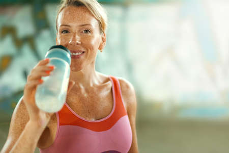 Woman in fitness wear doing workout with a heavy medicine ball outdoors.. Sporty girl with fit body in sportswear.の写真素材