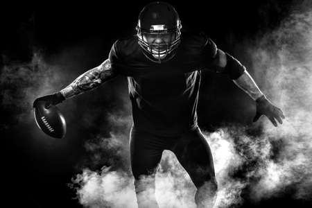 Sport concept. American football sportsman player on black background. Sport concept.の写真素材