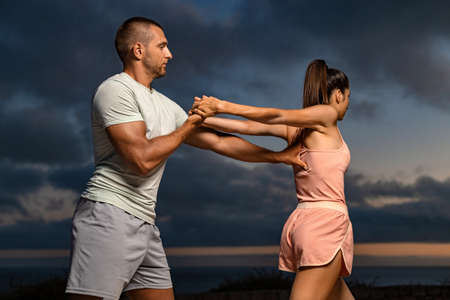 Full fody stretch with a trainer outdoors high resolution photo for social media posting. Stretching...