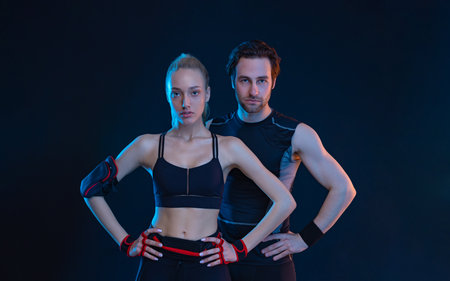Fit couple at the gym isolated on black background. Fitness concept. Healthy life style. Sports wallpaper for sports advertising. Picture for a sports article in a magazine, website.の写真素材