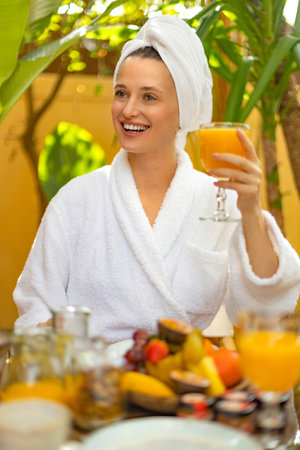 A beautiful girl is having breakfast at a hotel in Bali. Photo for social networks for hotel advertising. Image for womens magazines.の写真素材
