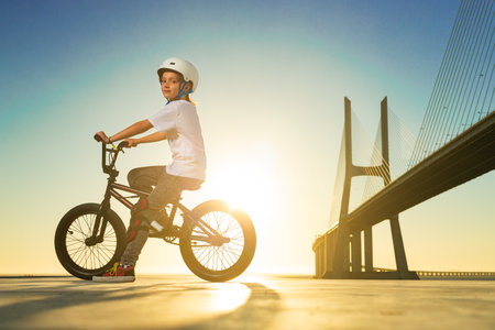 A teenager BMX Racing Rider performs tricks in a skate park on a pump track.の写真素材