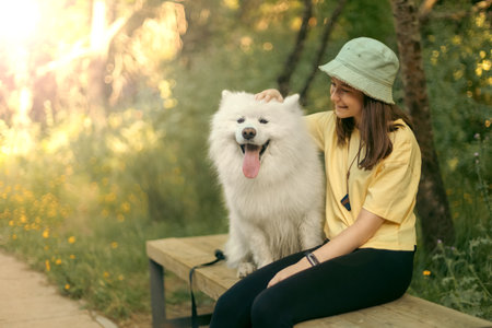 A teenage girl with her friend a Samoyed husky is hiking in the forest.の写真素材