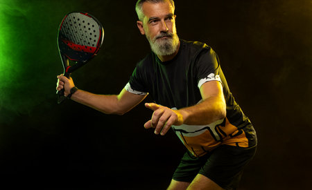 Padel tennis player with racket. Man athlete with paddle tenis racket on court with neon colors. Sport concept. Download a high quality photo for the design of a sports app or betting site.の写真素材