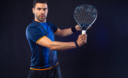 tennis player. Man athlete with paddle tennis racket on black background.の写真素材
