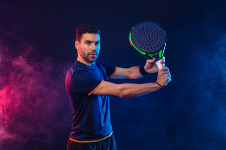 Padel tennis player. Man athlete with paddle tenis racket on black background. Sport concept. Download a high quality photo for sports website.の写真素材
