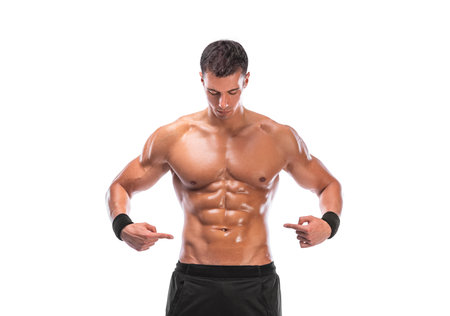 A man demonstrates the results of hard training, his inflated abs. Sportsmen isolated on white background. Fitness motivation. Photo for fitness mobile application.の写真素材