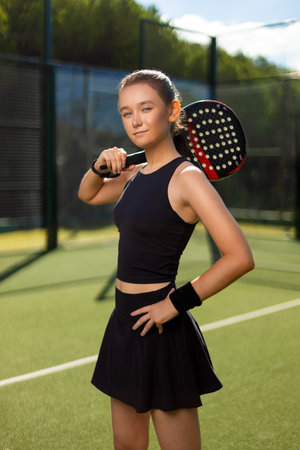 Padel tennis player with racket. Girl athlete with paddle racket on court outdoors. Sport concept. Download a high quality photo for the design of a sports app or web site.の写真素材