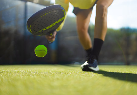 Close-up photo. Padel tennis player with racket. Girl athlete with paddle racket on court outdoors....