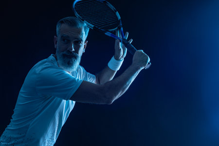 Tennis player man. Tennis open tour. Man athlete with paddle tenis racket and ball on blue background. Sport concept. Download a high quality photo for sports ads at social media stories or shorts.の写真素材