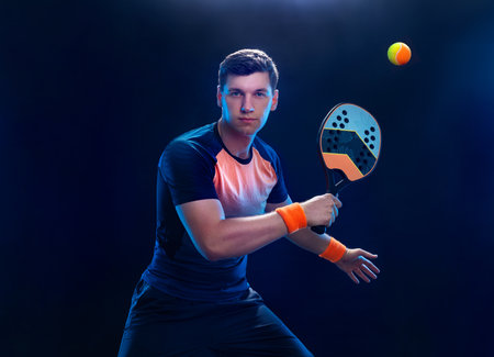 Beach tennis player with racket. Man athlete playing isolated on black background.の写真素材