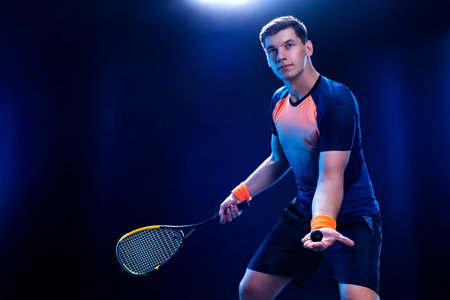 Squash player on a squash court with racket. Man athlete with racket on court with neon colors....