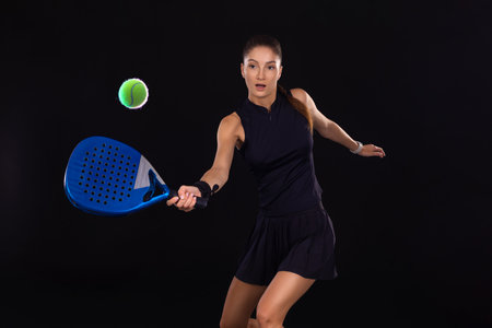 Padel tennis player with racket on tournament. Girl athlete with paddle racket on court with neon...