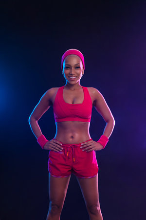 Sporty fit woman, athlete make fitness exercises on neon background. Download cover for music collection for fitness classes. Sports recreation. Beautiful black young woman.の写真素材