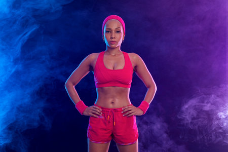 Sporty fit woman, athlete after fitness exercises on black background. Download cover for music collection for fitness classes. Sports recreation. Beautiful black young woman.の写真素材