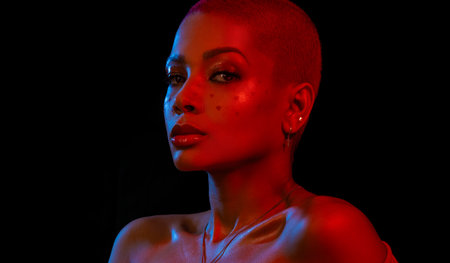 Creative makeup for Valentines day. Portrait of female fashion model in red neon light on black...