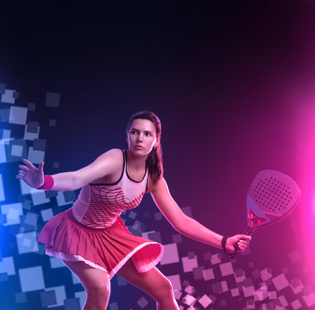 Padel tennis player with racket on tournament. Girl athlete with paddle racket on court with neon colors. Sport concept. Download a high quality photo for design of a sports app or tour events.の写真素材