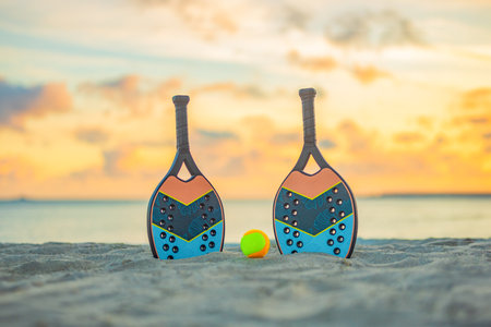 Beach tennis racket and ball on the sandy beach.. Background with copy space. Sport court at the beach and ball. Summer sport conceptの写真素材