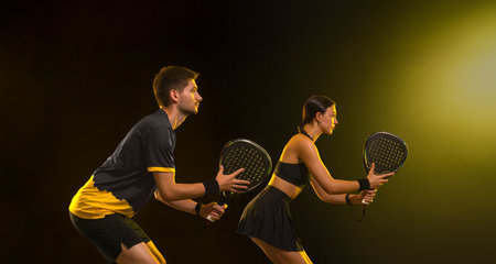 Padel tennis doubles. Two athletes players with racket. Man and woman with paddle racket on court. Sport concept. Download a high quality photo for the design of a sports appの写真素材