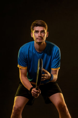 Padel Tennis Player with Racket in Hand. Paddle tenis, on a black background. Download in high resolution.の写真素材