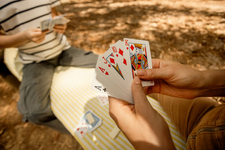 Father and daughter teenager playing card game. Creative outdoors leisure and education of kid. Family activity at the park.の写真素材