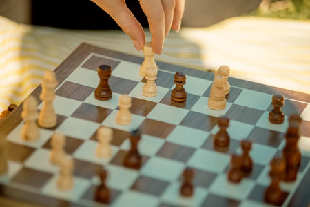 Game of chess. Family spending time in a summer park in nature on a sunny day. Board game, chess trainingの写真素材