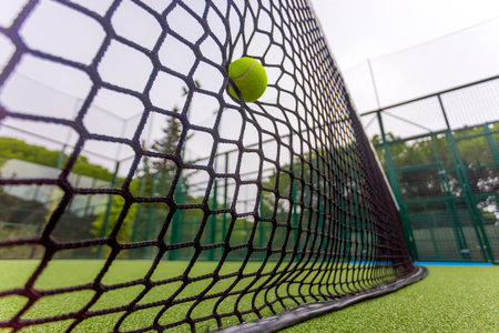 Padel or tennis ball in the net. Background with copy space. Sport court and ball. Social media template. Promotion for padel and tennis events.の写真素材