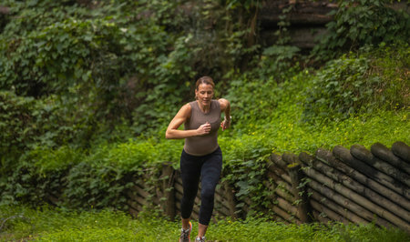 Active woman doing trail running in the forest. Traveler enjoying nature. Concept of active sport,...