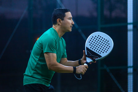 Padel player with racket on court in action at tournamentの写真素材