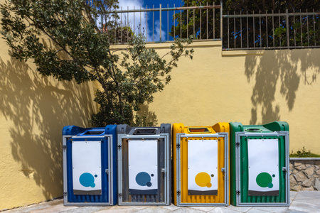 Colorful recycling bins and labeled trash containers placed on the street. Waste separation bins used for eco-friendly garbage disposalの写真素材