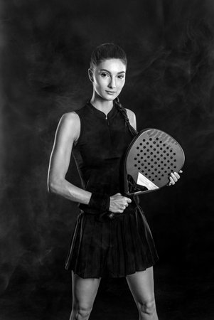 Padel tennis player with racket on tournament. Girl athlete with paddle racket on court. Sport concept. Download a high quality photo for design of a sports app or tour events. Black and white.の写真素材