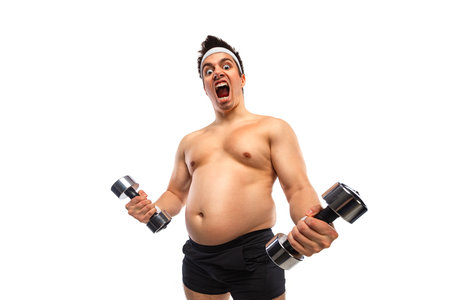 Overweight man exercising with dumbbells trying to lose weight during home workout focused on fitness health and weight loss motivation body transformation and healthy lifestyle conceptの写真素材