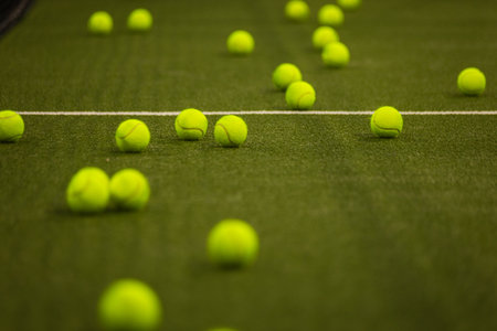Padel balls on court during sunny day, clean and minimalistic image for sports websites, blogs, and promotional materials.の写真素材