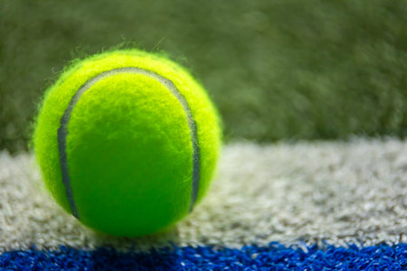 Padel or tennis ball. Background with copy space. Ball at sports court. Social media template. Promotion for padel events.の写真素材