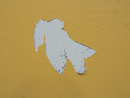 Peeling paint on a  concrete surface with yellow colorの写真素材