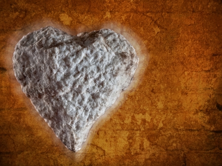 white textured stone in the shape of a heart, tough loveの写真素材