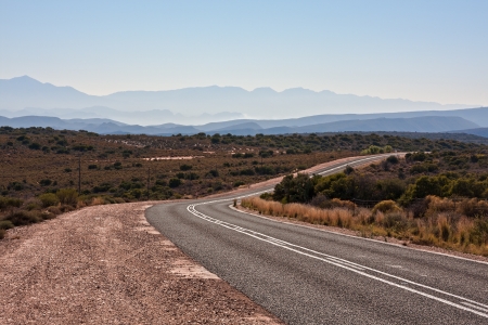 viewpoint of distant mountains with a country road receeding into the distanceの写真素材