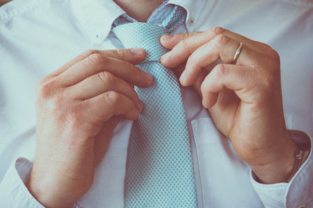 Business Man adjusting his necktie before going to workの写真素材