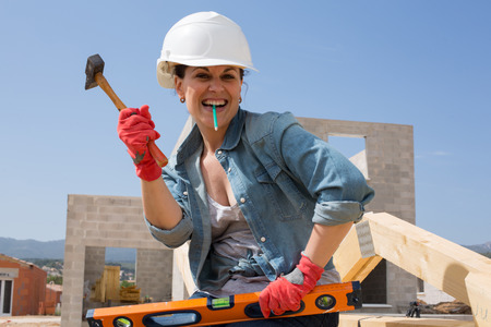 Woman works on a construction site of a house - Funny conceptの写真素材