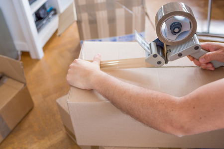 Closeup of Man Packing Boxes - House Moving Concept