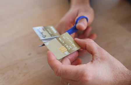 Man cutting his credit card with scissorsの写真素材