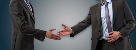 Handshake between two businessmen on a modern backgroundの写真素材