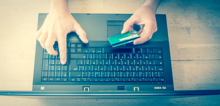 Man shopping online using laptop with credit card
