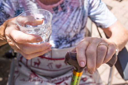 Elderly woman with glass of water in handの写真素材